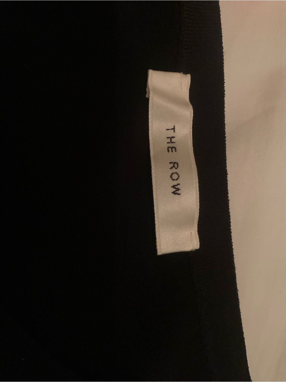 The Row Black Top with White Brand Tag